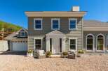 Charming home with a welcoming entrance, featuring a white double door and elegant columns.