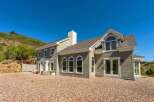 This stunning home boasts a charming exterior with light green siding and a welcoming white-trimmed entrance.