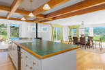 Experience breathtaking mountain views from this spacious kitchen and dining area, featuring a large island with a sink and ample cabinet space.