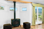 Cozy up by the green cast-iron wood stove in this charming room, perfect for chilly evenings.