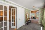 Step into this charming entryway featuring a unique floral wallpaper and a stone floor.