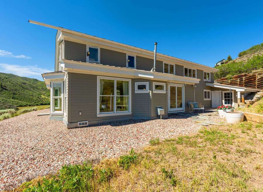 This stunning home offers a unique architectural design with a striking angled roofline and expansive windows that capture the breathtaking mountain views.