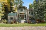 This stunning modern home features a unique architectural design with curved roofs and expansive windows that flood the interior with natural light.