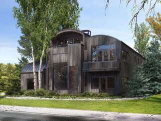 Experience modern architectural brilliance with this stunning home, featuring a unique curved roofline and dark wood siding that blends seamlessly with the natural surroundings.