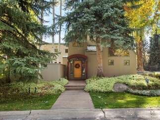 Charming home with a welcoming entryway featuring a bright yellow door and a festive wreath.