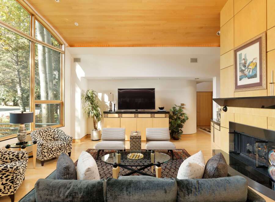 Experience luxurious living in this stunning contemporary living room, featuring a dramatic floor-to-ceiling window wall that floods the space with natural light.
