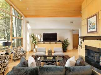 Experience luxurious living in this stunning contemporary living room, featuring a dramatic floor-to-ceiling window wall that floods the space with natural light.