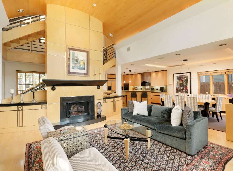 Experience luxury living in this stunning open-concept home, featuring a grand fireplace as the centerpiece of the living area.