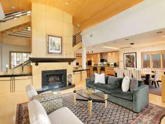 Experience luxury living in this stunning open-concept home, featuring a grand fireplace as the centerpiece of the living area.
