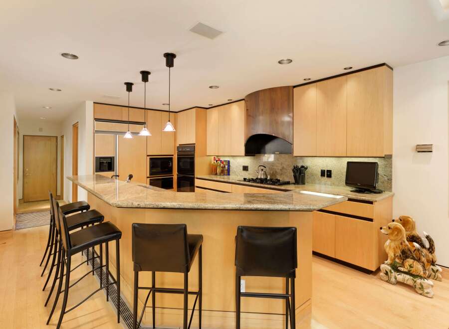 This spacious kitchen boasts a large granite island with ample seating, perfect for casual dining and entertaining.