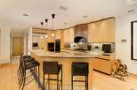 This spacious kitchen boasts a large granite island with ample seating, perfect for casual dining and entertaining.