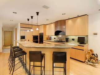 This spacious kitchen boasts a large granite island with ample seating, perfect for casual dining and entertaining.