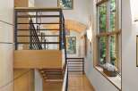 Experience modern luxury in this stunning home featuring a striking multi-level staircase with sleek black railings and warm wood accents.