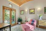 This inviting room features a plush pink chaise lounge, perfect for relaxation, complemented by a soft, textured rug.