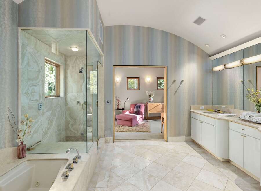Indulge in luxury with this stunning bathroom featuring a spacious glass-enclosed shower and a deep soaking tub, perfect for unwinding.