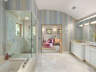 Indulge in luxury with this stunning bathroom featuring a spacious glass-enclosed shower and a deep soaking tub, perfect for unwinding.