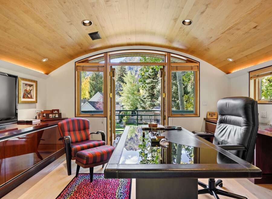 Experience luxury and productivity in this executive office, featuring a sleek glass-top desk and a comfortable leather executive chair.