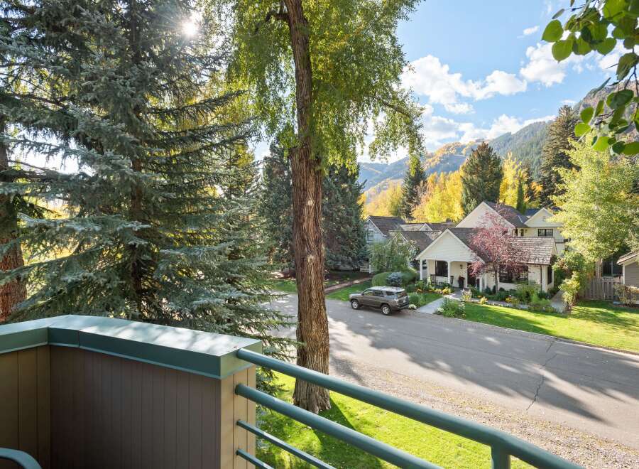 Experience the charm of autumn in this picturesque neighborhood, featuring beautiful homes nestled amongst vibrant fall foliage and mature trees.