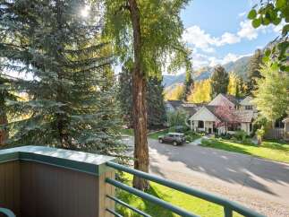 Experience the charm of autumn in this picturesque neighborhood, featuring beautiful homes nestled amongst vibrant fall foliage and mature trees.