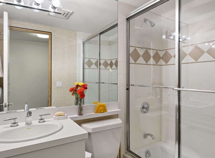 This bright and clean bathroom features a spacious vanity with a double sink and modern chrome fixtures.