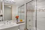 This bright and clean bathroom features a spacious vanity with a double sink and modern chrome fixtures.