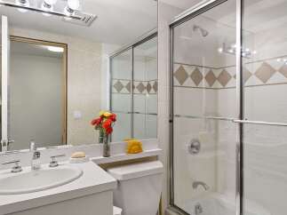 This bright and clean bathroom features a spacious vanity with a double sink and modern chrome fixtures.