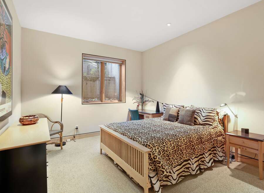 This charming bedroom features a comfortable queen-size bed adorned with a playful leopard print comforter and matching throw pillows.