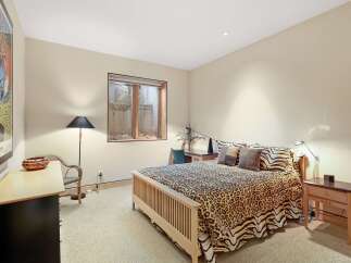 This charming bedroom features a comfortable queen-size bed adorned with a playful leopard print comforter and matching throw pillows.