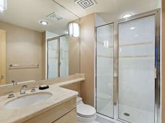 This elegant bathroom features a spacious vanity with a marble countertop and a modern faucet, complemented by a large mirror.