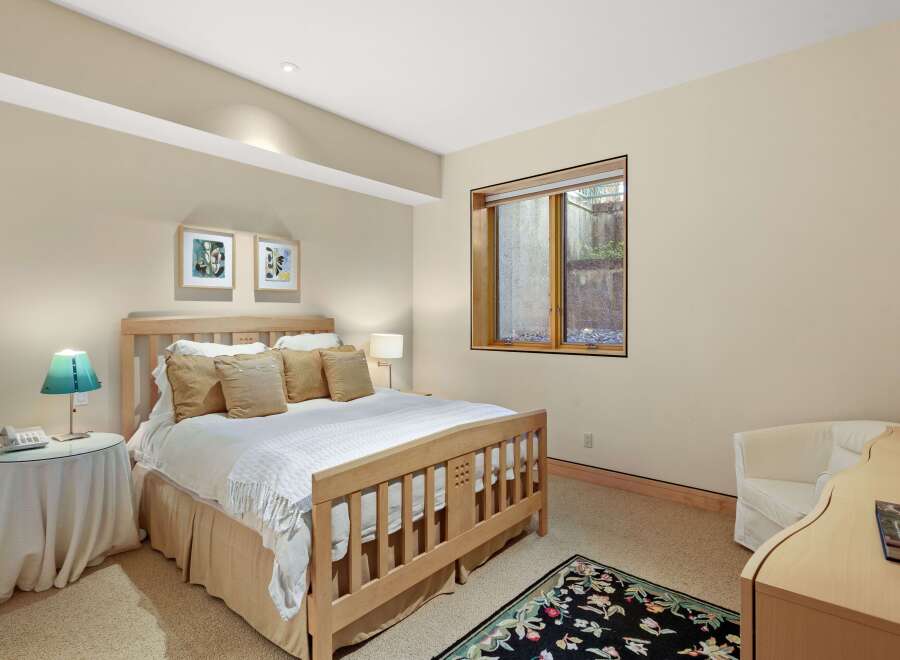 This inviting bedroom features a comfortable queen-size bed with plush pillows and a cozy throw blanket, perfect for relaxation.