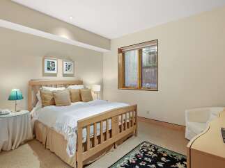This inviting bedroom features a comfortable queen-size bed with plush pillows and a cozy throw blanket, perfect for relaxation.