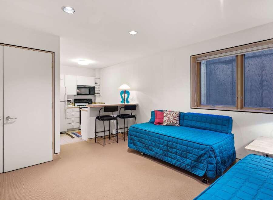 Discover this charming studio apartment featuring a compact kitchen with essential appliances and a breakfast bar perfect for casual dining.
