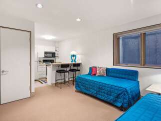 Discover this charming studio apartment featuring a compact kitchen with essential appliances and a breakfast bar perfect for casual dining.