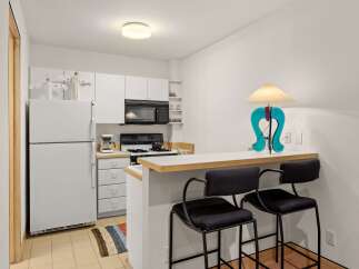 Discover this charming kitchen featuring a full-sized refrigerator, a microwave, and a gas range perfect for home-cooked meals.