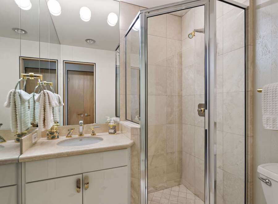 Experience luxury in this beautifully appointed bathroom featuring a spacious vanity with a double sink and elegant gold fixtures.