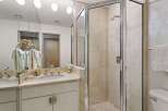 Experience luxury in this beautifully appointed bathroom featuring a spacious vanity with a double sink and elegant gold fixtures.