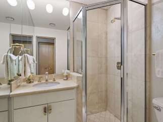 Experience luxury in this beautifully appointed bathroom featuring a spacious vanity with a double sink and elegant gold fixtures.