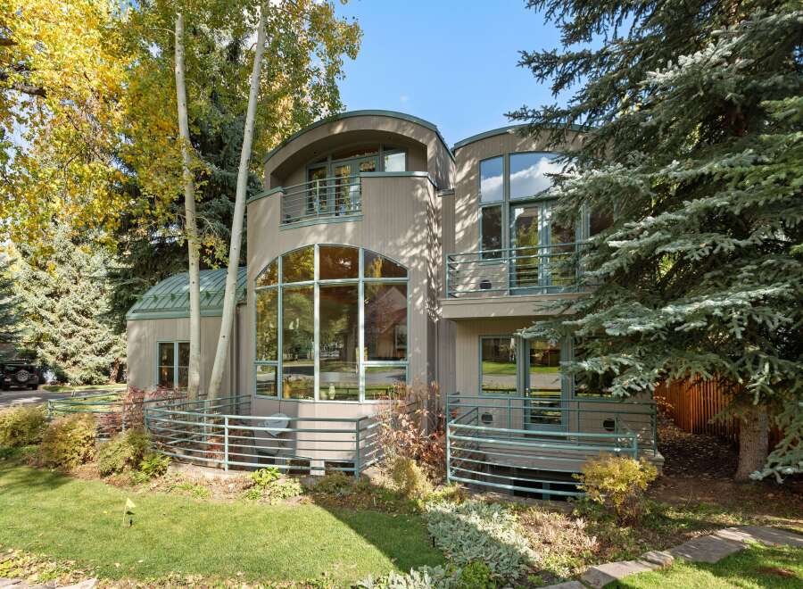 Experience modern living in this unique home featuring striking architectural curves and expansive windows that invite natural light.