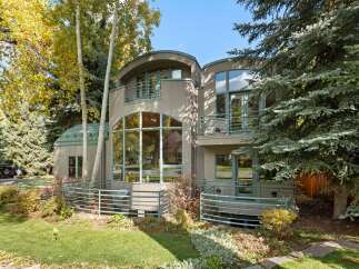Experience modern living in this unique home featuring striking architectural curves and expansive windows that invite natural light.