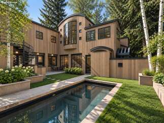 Experience modern luxury in this stunning home featuring a sleek wooden exterior and a private swimming pool.