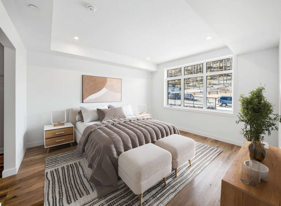 Experience modern comfort in this beautifully appointed bedroom, featuring a plush king-sized bed with elegant taupe bedding and a striking abstract art piece above.