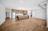 Experience modern living in this spacious open-concept kitchen and living area, featuring sleek wooden cabinetry and a large island perfect for entertaining.
