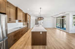 Experience modern living in this stunning kitchen featuring sleek, custom wood cabinetry and a spacious island with a waterfall countertop.