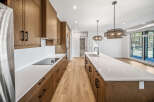 Experience modern living in this stunning kitchen featuring sleek, custom wood cabinetry and expansive quartz countertops.