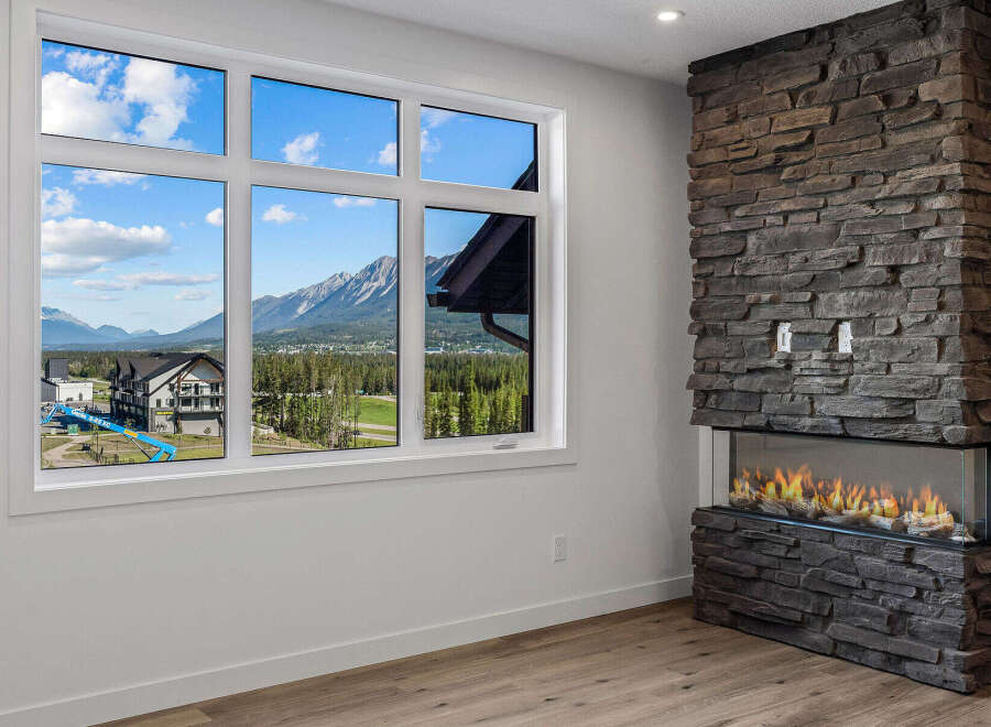 Experience breathtaking mountain views from this stunning property, framed perfectly by a large, multi-pane window.