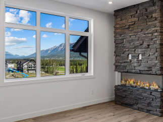 Experience breathtaking mountain views from this stunning property, framed perfectly by a large, multi-pane window.