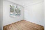 Discover modern living in this bright and airy room featuring a large window with scenic views of a wooded hillside.