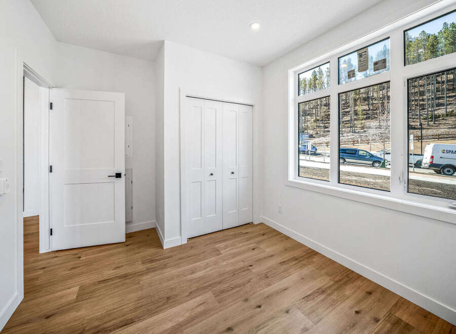 Discover modern living in this bright and airy room, featuring a spacious closet and large windows that flood the space with natural light.