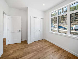 Discover modern living in this bright and airy room, featuring a spacious closet and large windows that flood the space with natural light.
