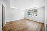 Experience modern living in this bright and airy space, featuring a stunning tray ceiling with recessed lighting and a large, picturesque window that floods the room with natural light.